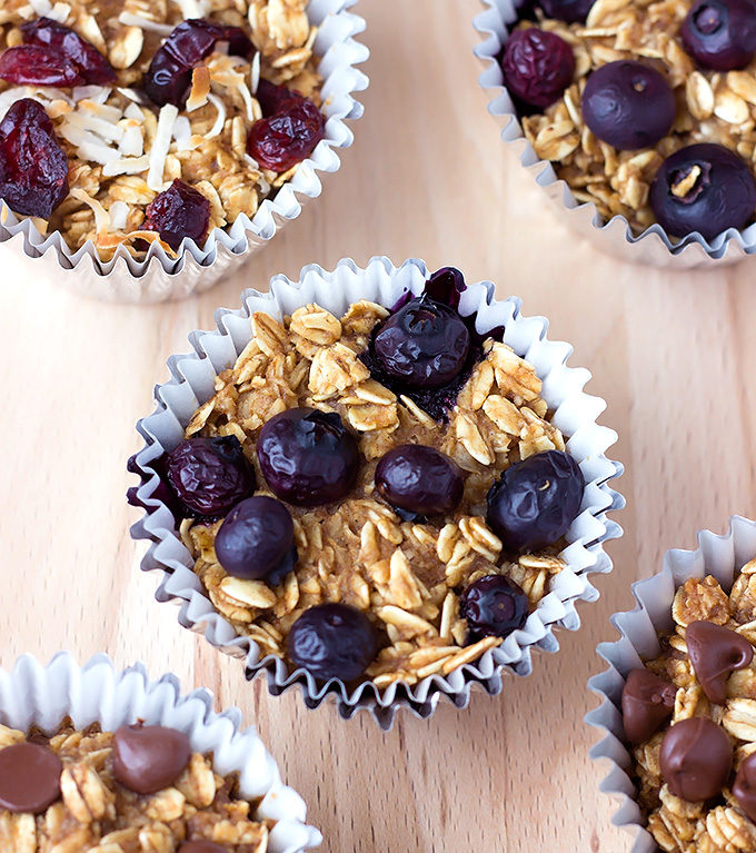 Customizable Baked Oatmeal Muffins recipe with different toppings on a cutting board