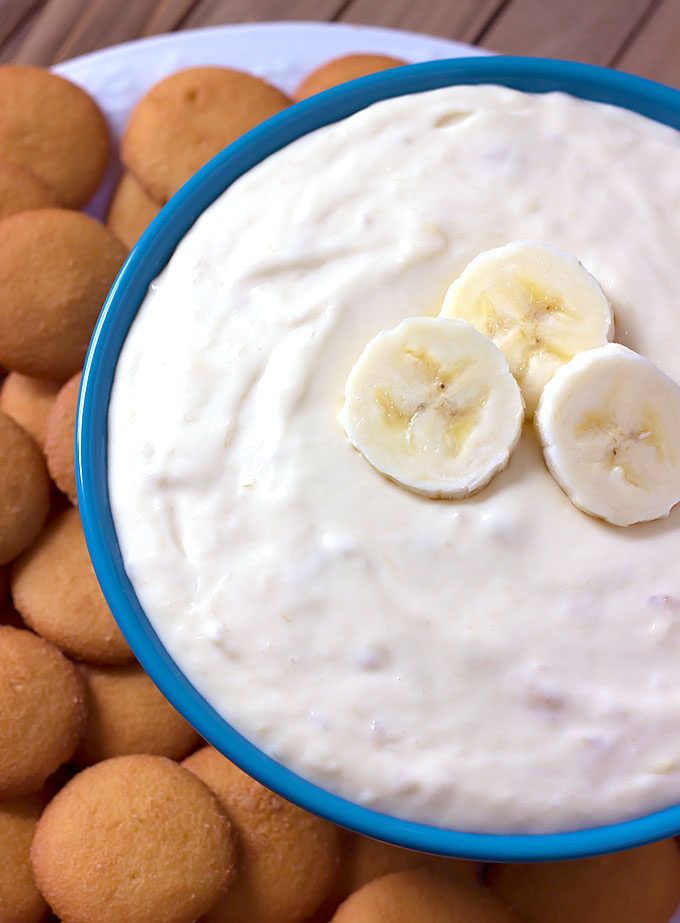 Banana Pudding Cheesecake Dip in a blue bowl with vanilla wafers around it