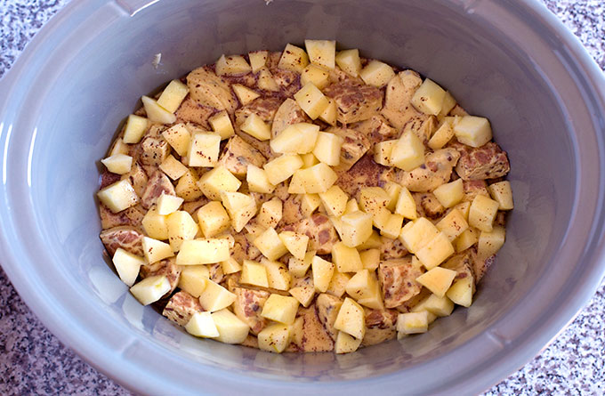 unbaked Crock Pot Apple Cinnamon Roll Casserole in a grey slow cooker