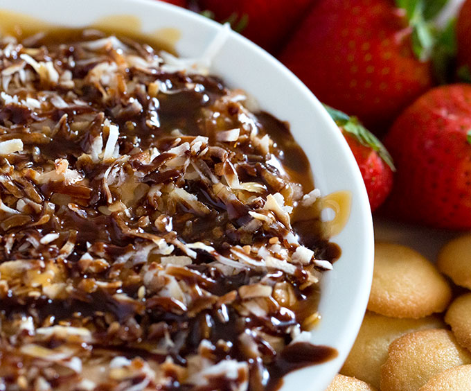Samoas Dip in a serving bowl with fruit and cookies