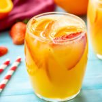 White sangria in a glass with orange slices and strawberries