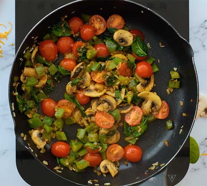 vegetables being sautéed in a skillet