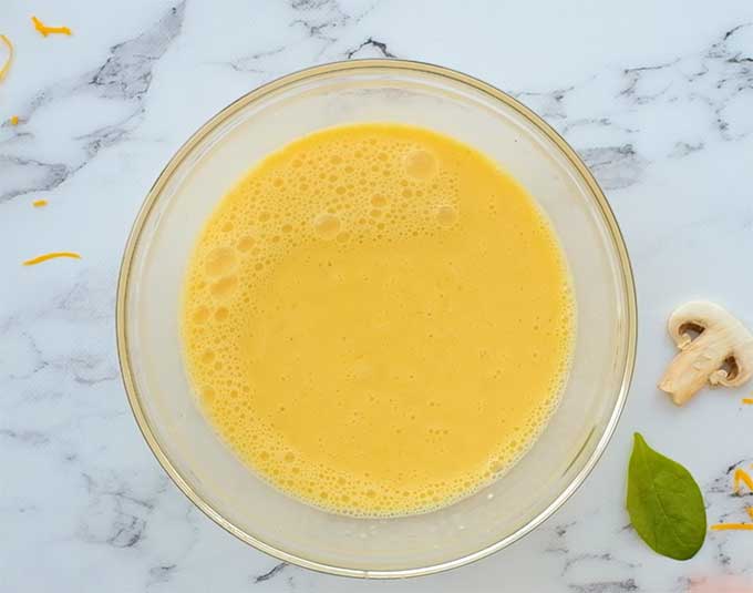 mixing bowl full of eggs mixed with milk