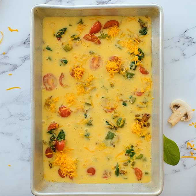 baking dish full of uncooked vegetable breakfast casserole