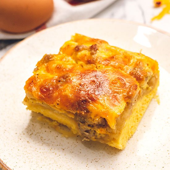 piece of breakfast casserole with sausage, eggs, cheese, and crescents