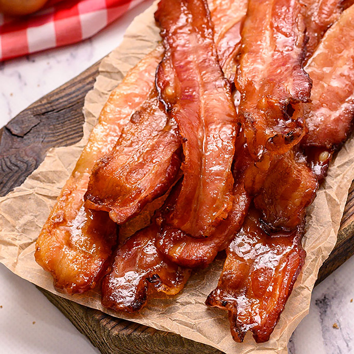 Baked Brown Sugar Bacon in a pile on a cutting board