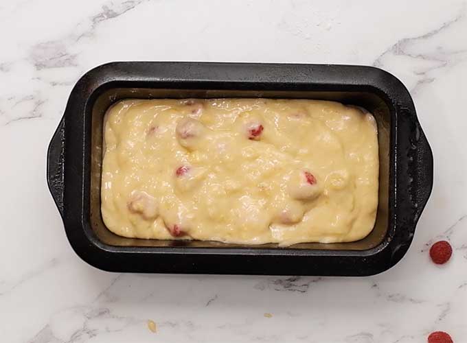 raspberry banana bread batter in a loaf pan