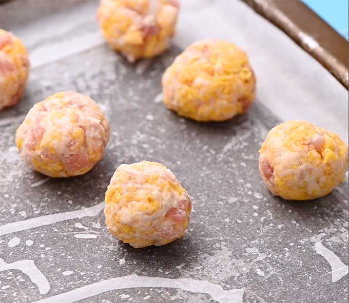 Uncooked sausage balls on a baking sheet