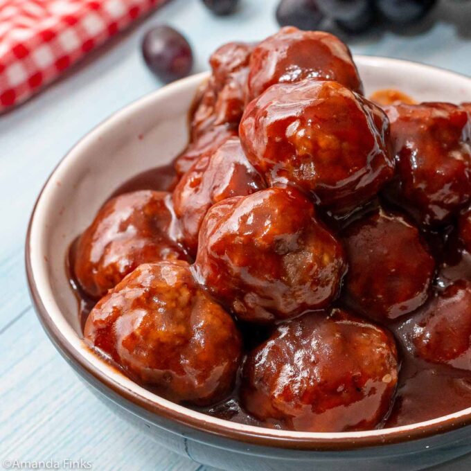 Meatballs coated in grape jelly BBQ sauce in a bowl