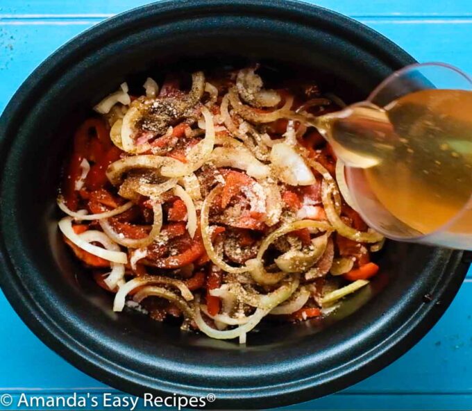 broth being poured over peppers and onions