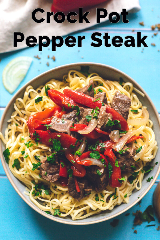 large bowl of pepper steak over cooked pasta with a text overlay