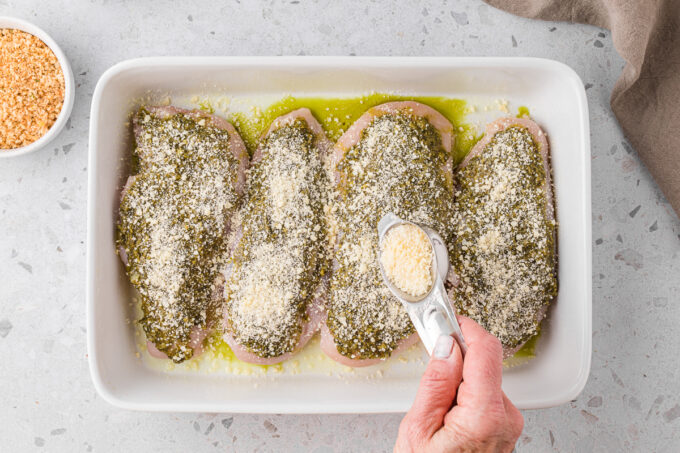 Sprinkling parmesan over the pesto.