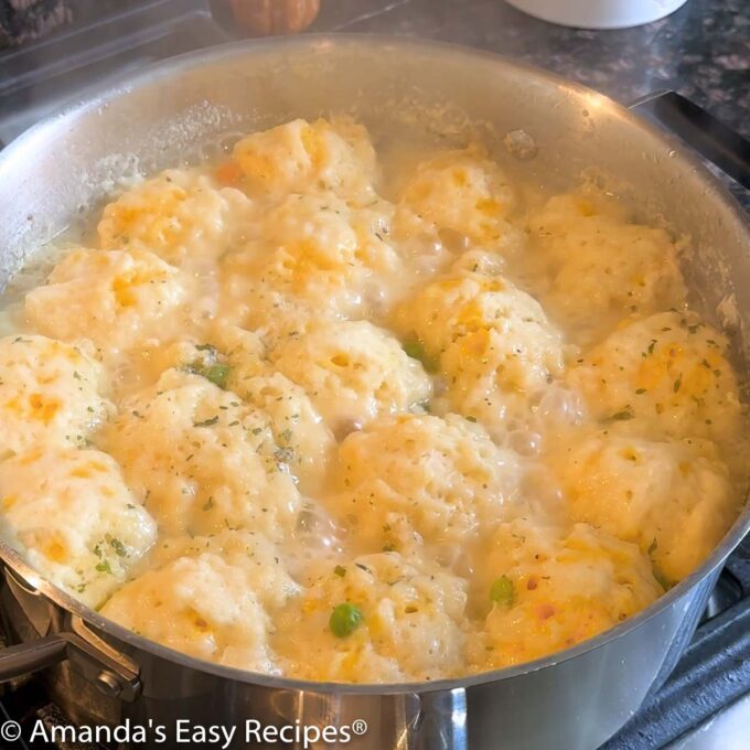 Dumplings simmering in liquid.