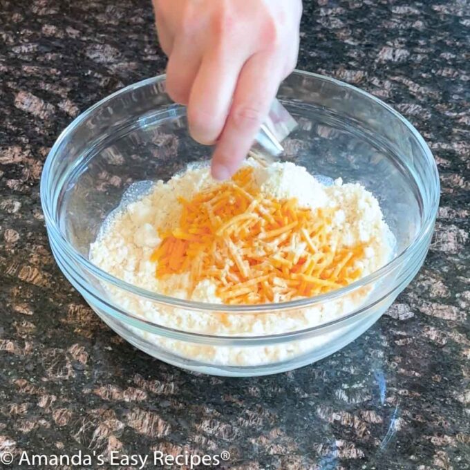 A mixing bowl full of cheddar bay biscuit mix ingredients.