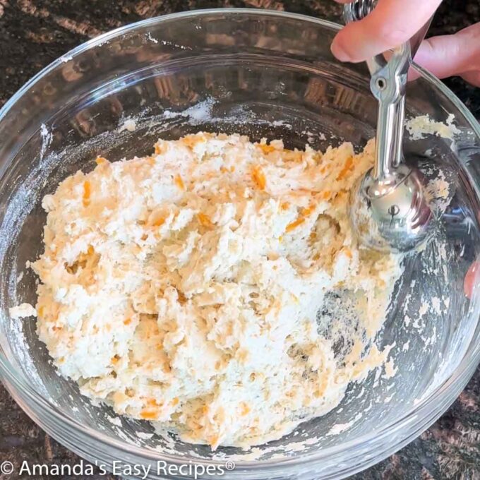 Scooping batter out of the bowl.