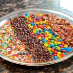 Caramel apple cheesecake dip with assorted toppings.