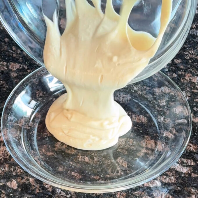 Pouring cheesecake mixture into a pie plate.