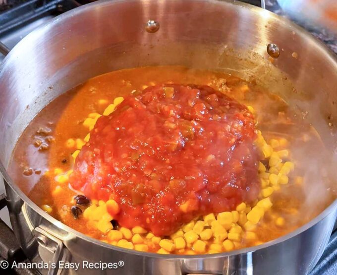 Black beans, corn, and salsa being added to the pot.
